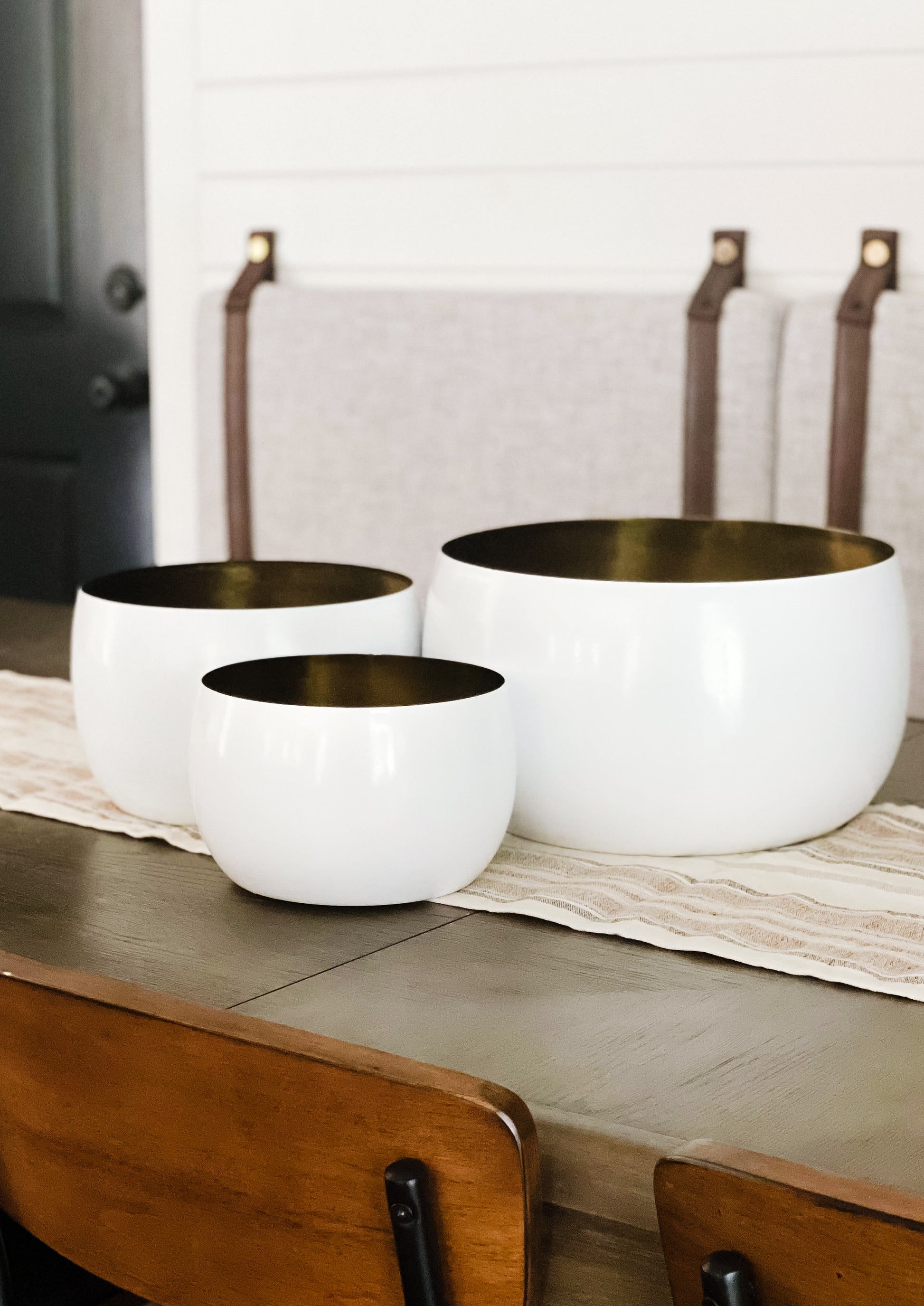 Decorative white bowls with antique brass finish on dining table.