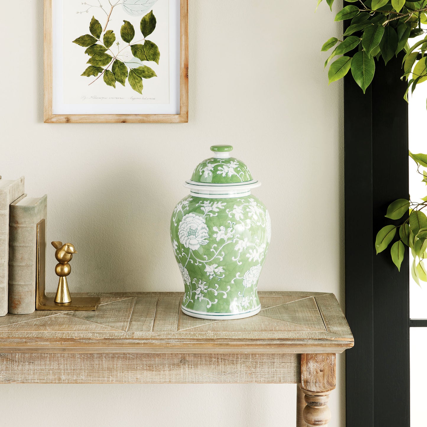 Chinoiserie green and white medium porcelain ginger jar stylized on wooden console table.