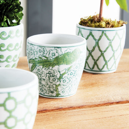 Chinoiserie green and white porcelain flower pots stylized on table.