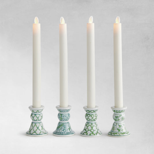 Set of 4 chinoiserie green and white porcelain taper holders with gray background.