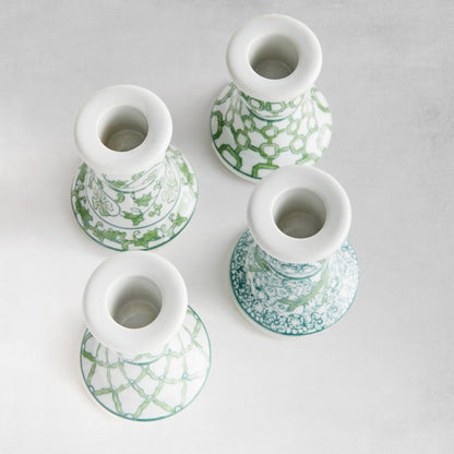 Set of 4 chinoiserie green and white porcelain taper holders, top view.