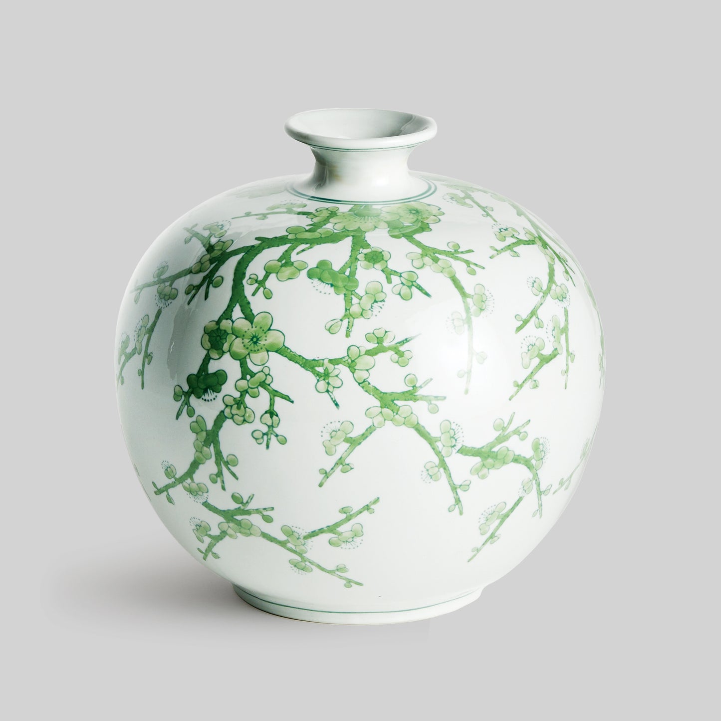 Chinoiserie green and white porcelain vase with gray background.