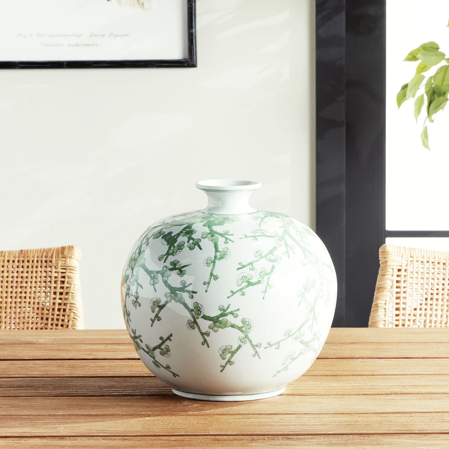 Chinoiserie green and white porcelain vase sitting on wood dining room table.