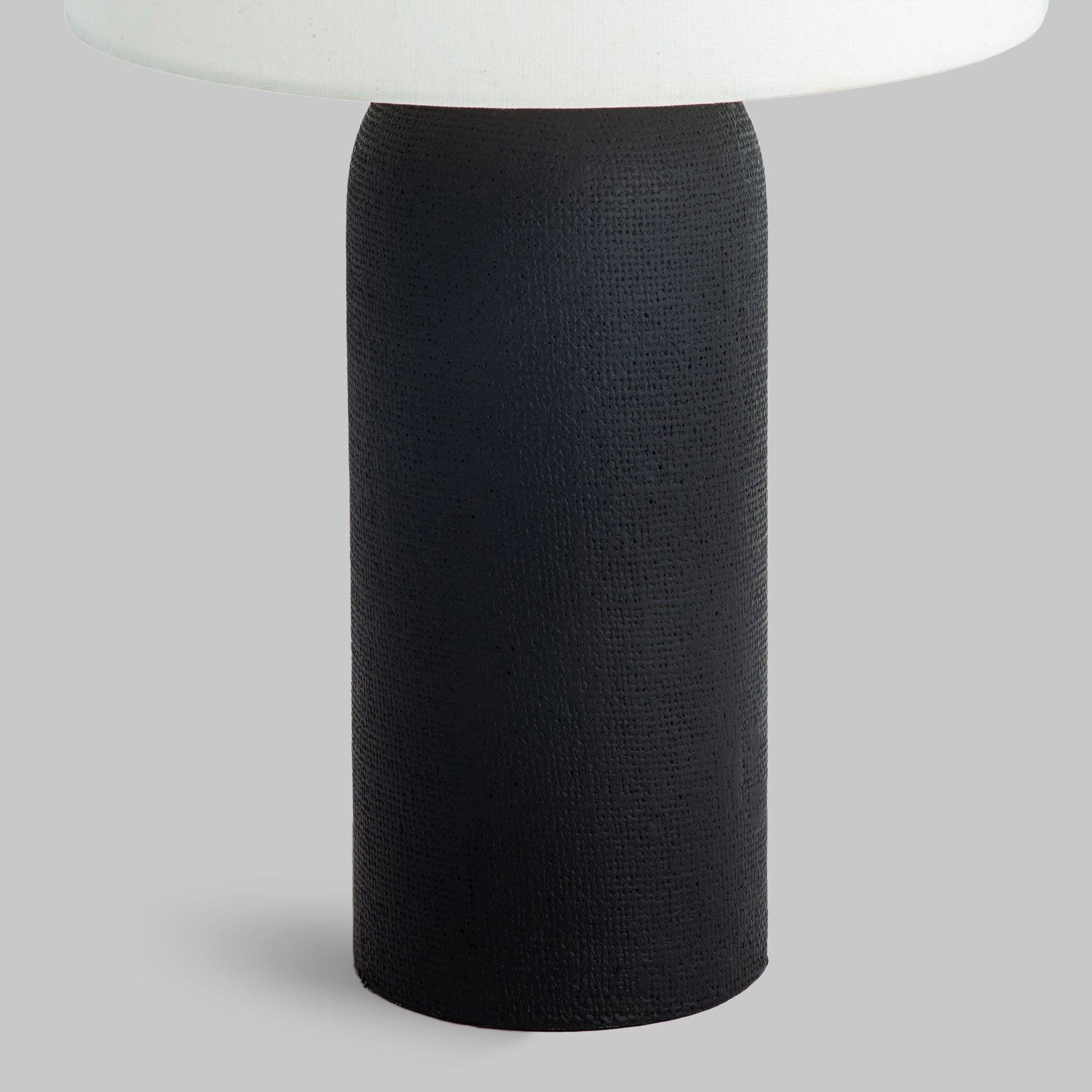 Contemporary black textured table lamp, closeup view of lamp base.