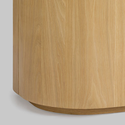 Contemporary round oak side table, natural finish, closeup view.