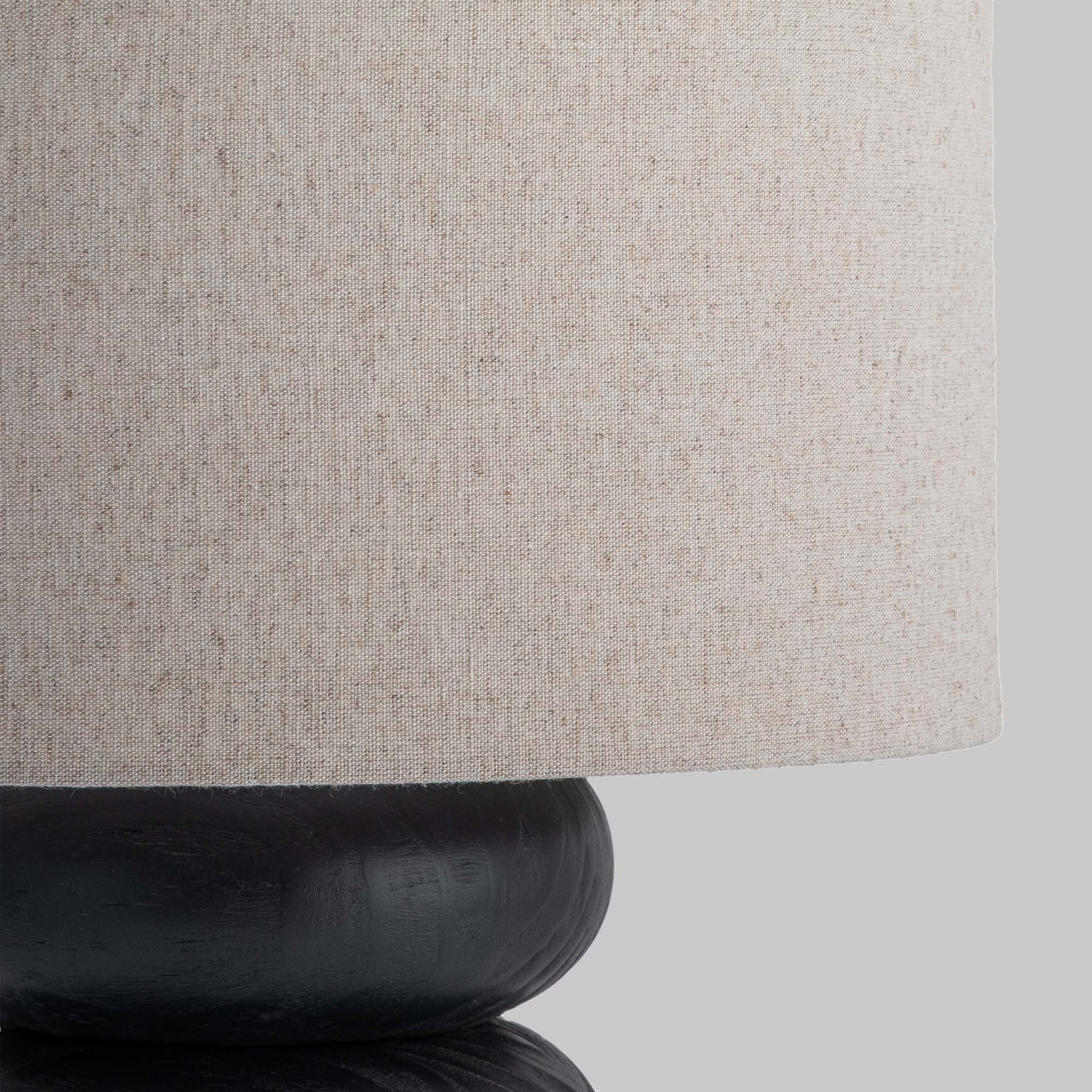 Contemporary stacked wood ring table lamp with black finish, closeup view of lampshade.