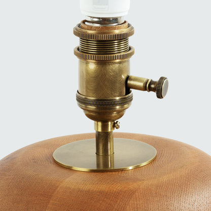 Contemporary stacked wood ring table lamp with natural finish, closeup view of hardware.