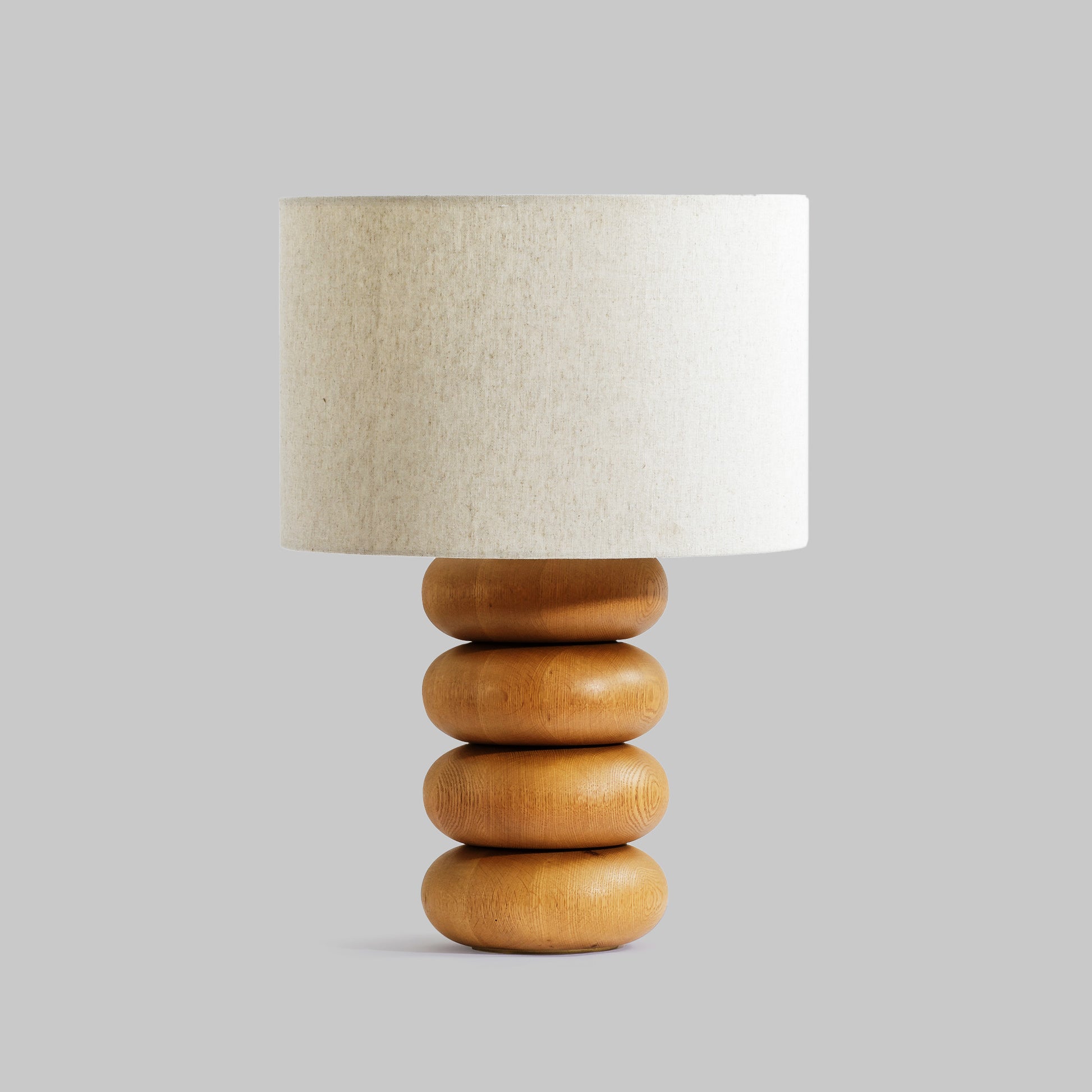 Contemporary stacked wood ring table lamp with natural finish.