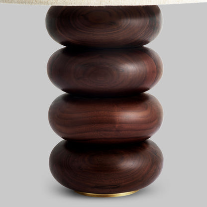 Contemporary stacked wood ring table lamp with walnut finish, closeup view.