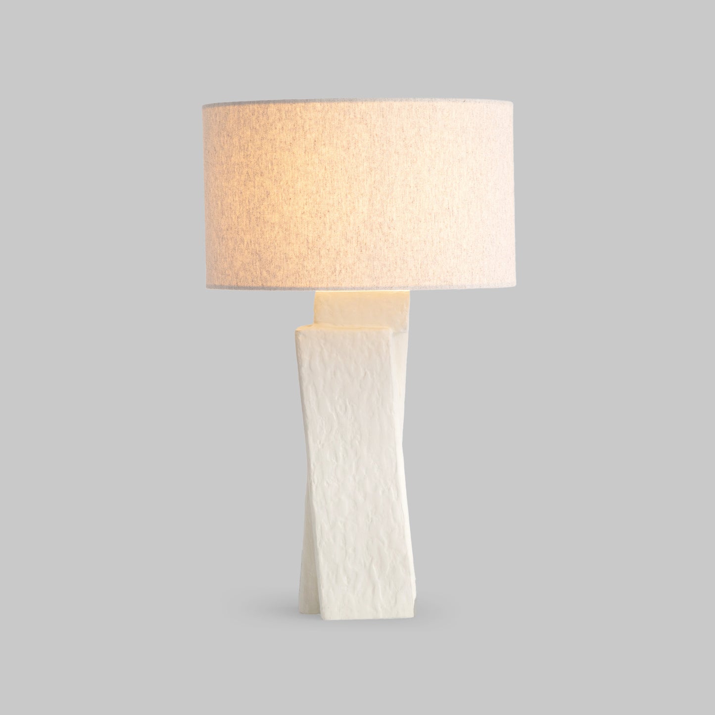 Contemporary white plaster table lamp, illuminated side view.