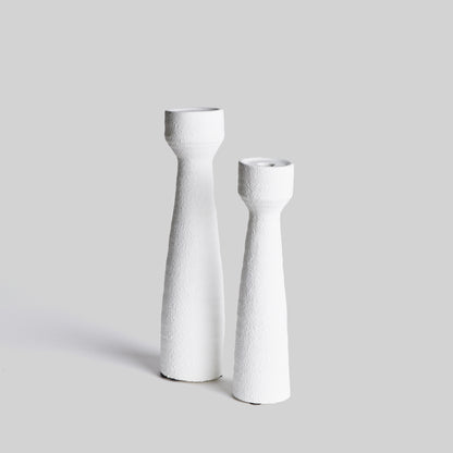 Contemporary white terracotta candleholders, set of 2, with gray background.