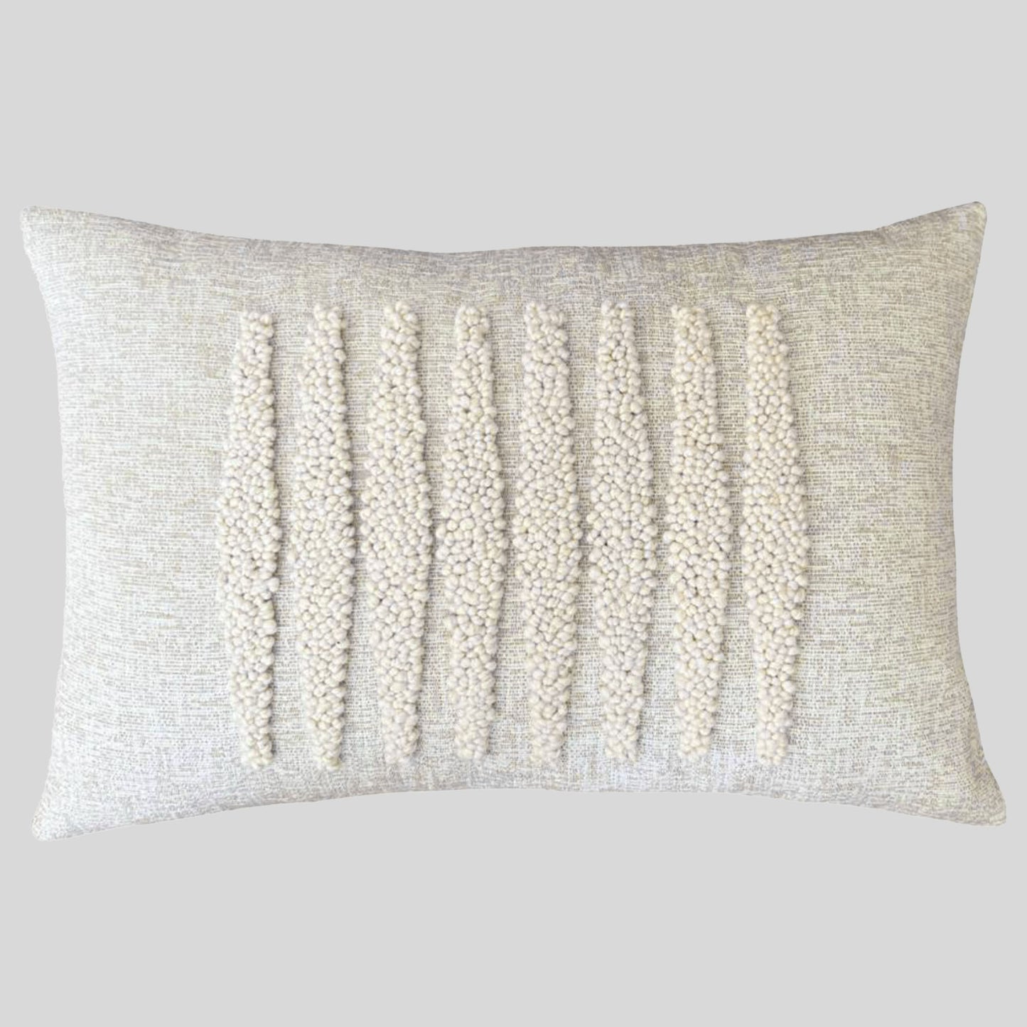 Cream colored embroidered lumbar pillow with gray background.