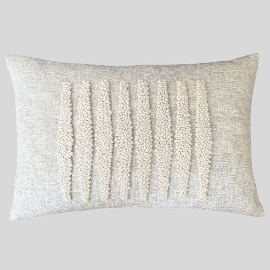 Cream colored embroidered lumbar pillow with gray background.