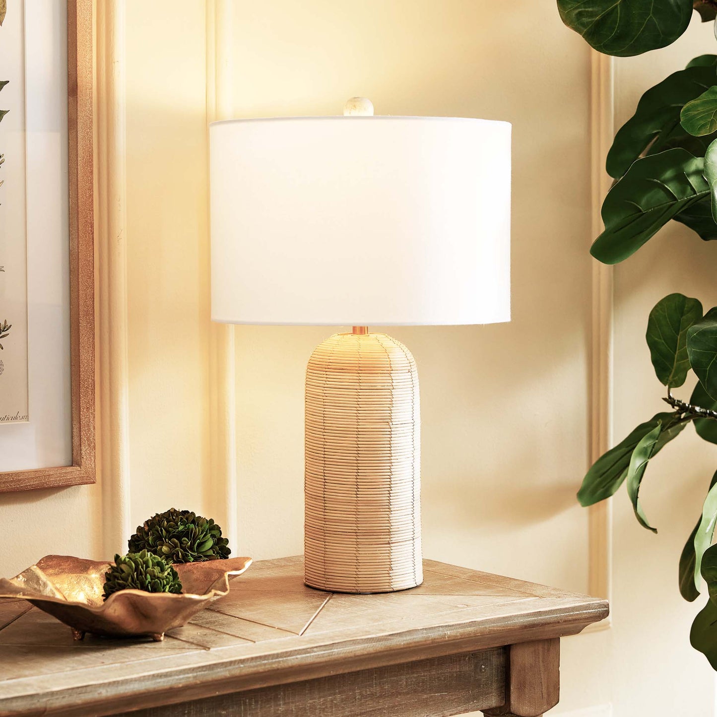 Cylindrical cane rattan table lamp stylized on console table.