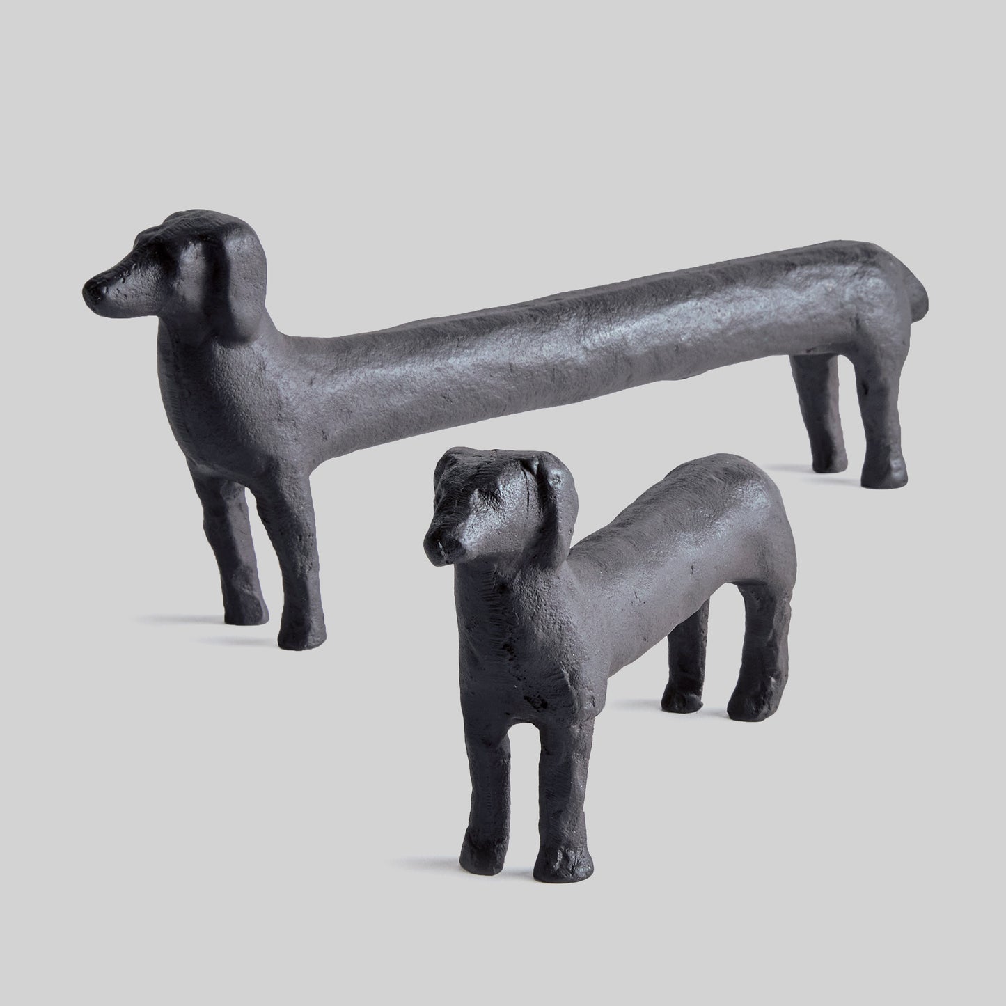 Dachshund decorative objects with black finish, set of 2, with gray background.