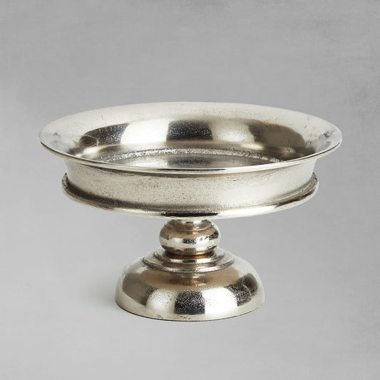 Decorative brushed nickel pedestal with gray background.