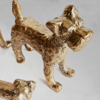 Decorative dog objects, set of 3, closeup view with gray background.