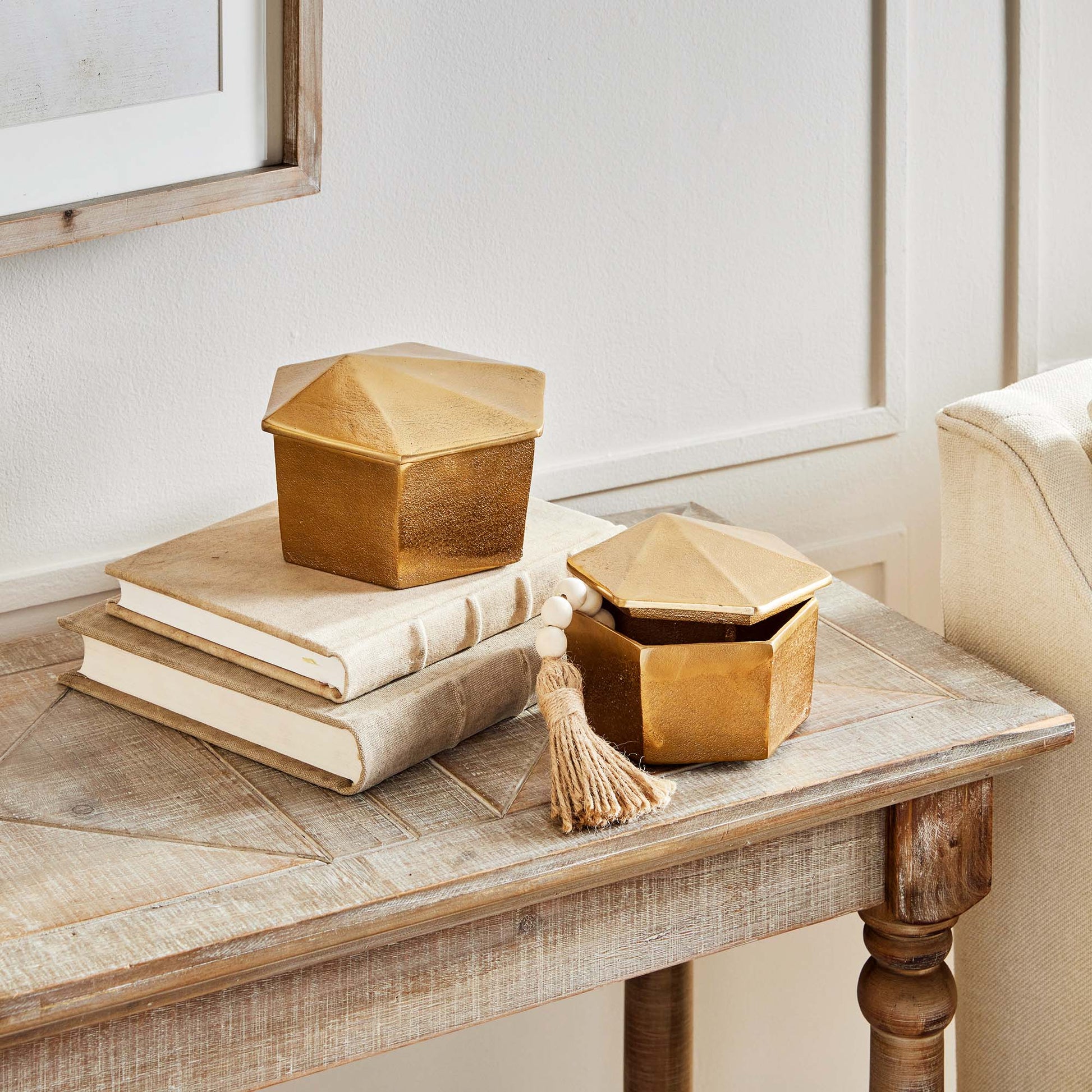 Decorative gold geometric lidded boxes stylized on table.