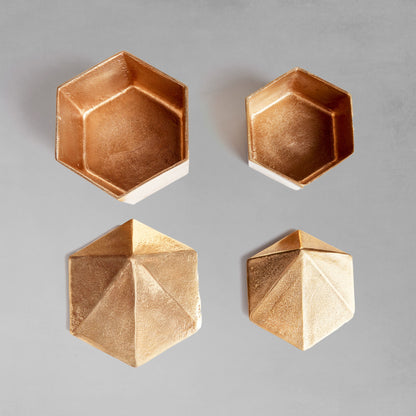 Decorative gold geometric lidded boxes, removed lids, with gray background.