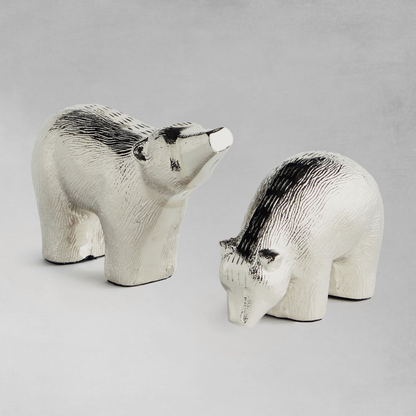 Decorative silver bears, set of two, with gray background.