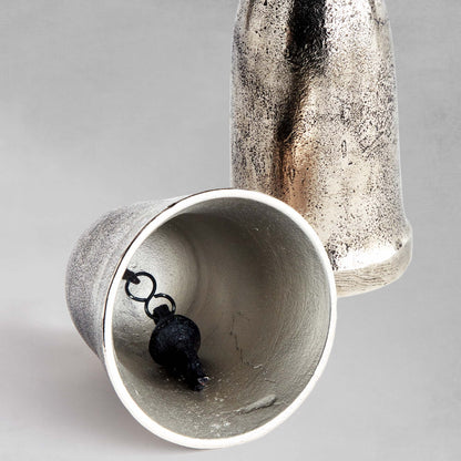 Decorative silver bells, set of 2, close-up view if inside of bell with gray background.