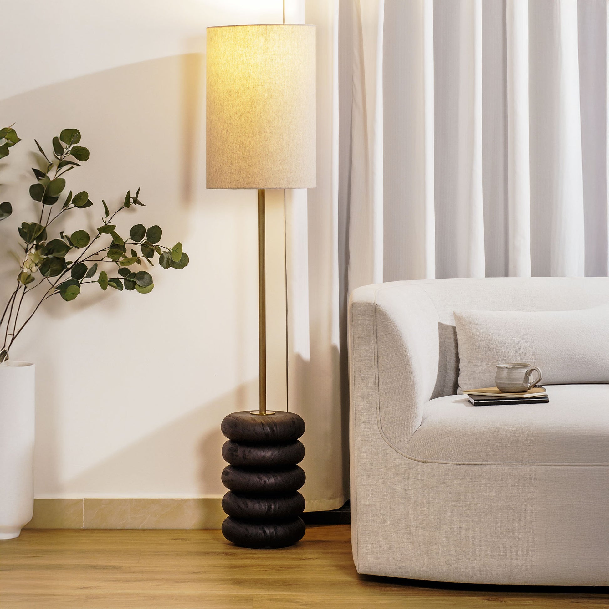 Floor lamp with a stacked circular wood base stylized in living room.
