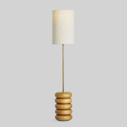 Floor lamp with a stacked circular wood base on a light gray background.
