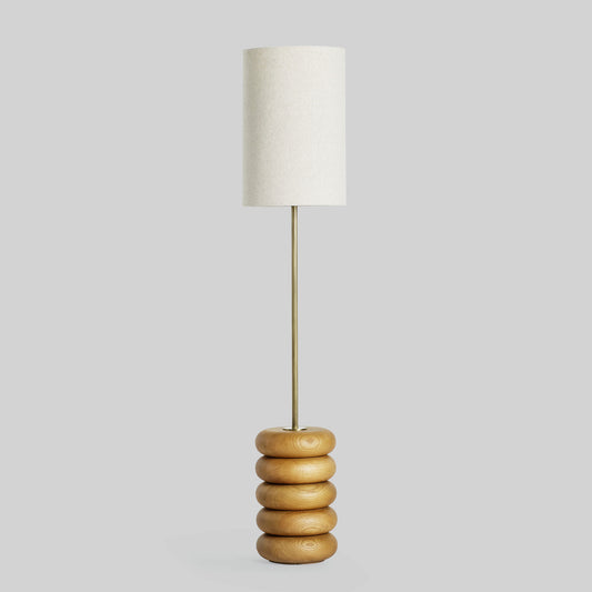 Floor lamp with a stacked circular wood base on a light gray background.