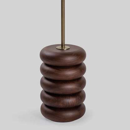 Floor lamp with a stacked circular wood base on a light gray background.