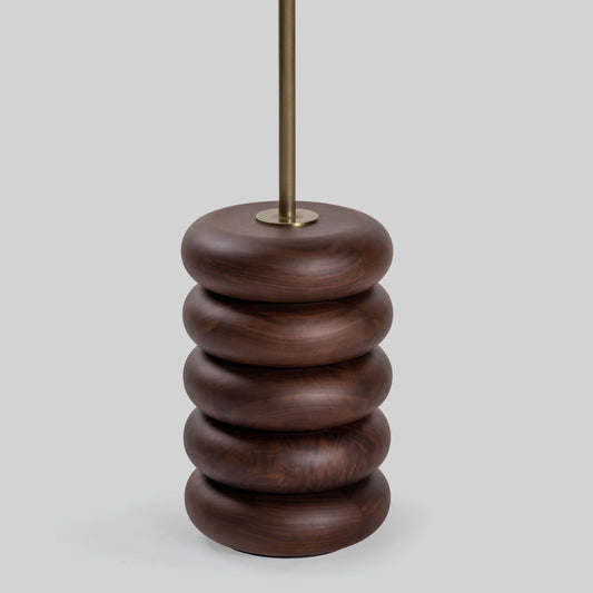 Floor lamp with a stacked circular wood base on a light gray background.
