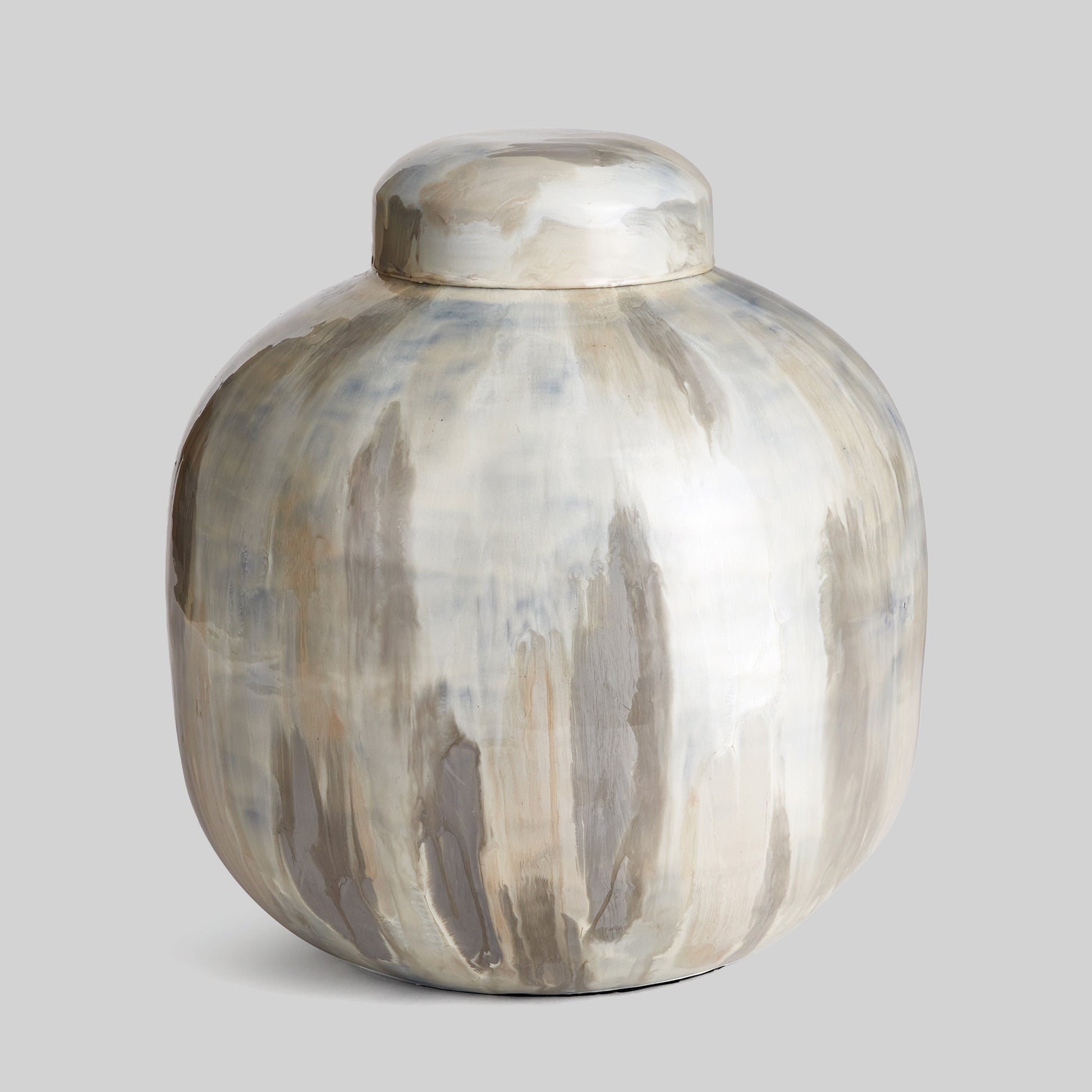 Enamel painted metal decorative jar with gray background.