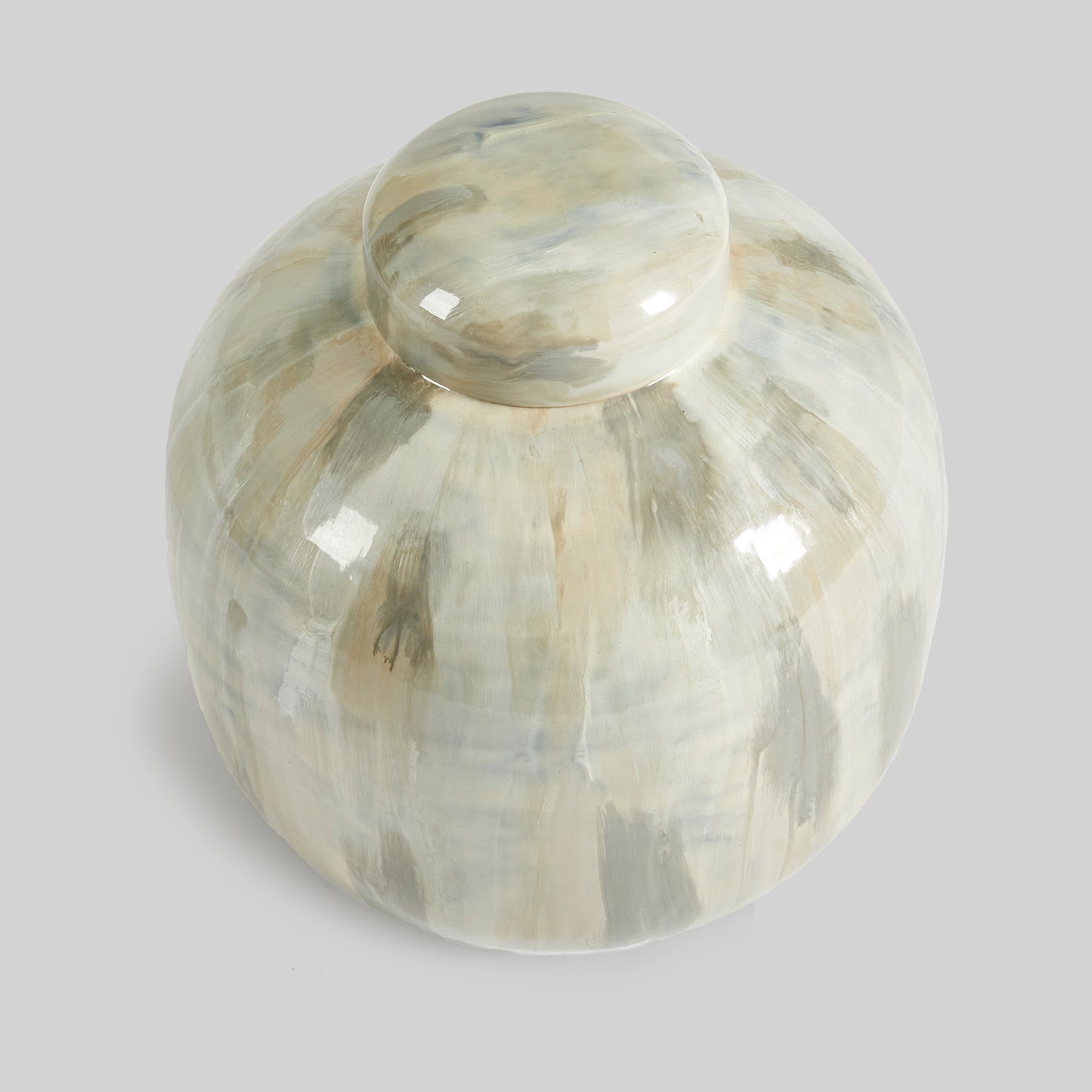 Enamel painted metal decorative jar, top view, with gray background.