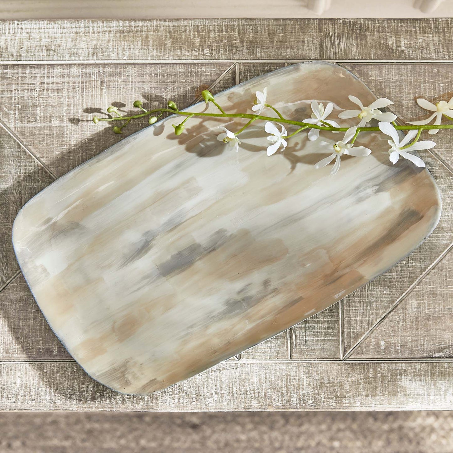 Enameled painted decorative metal tray, top view,  stylized on table.