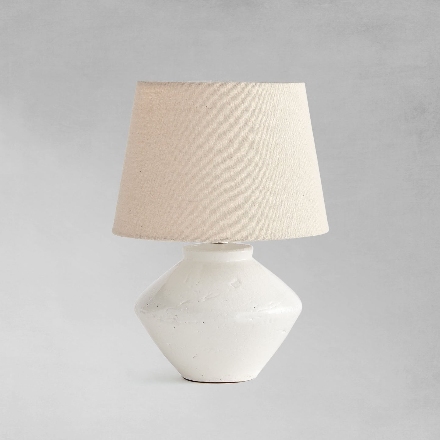 Glazed white mini lamp with gray background.