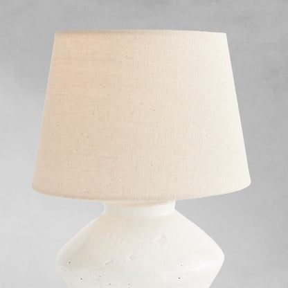 Glazed white mini lamp, closeup view of lampshade, with gray background.