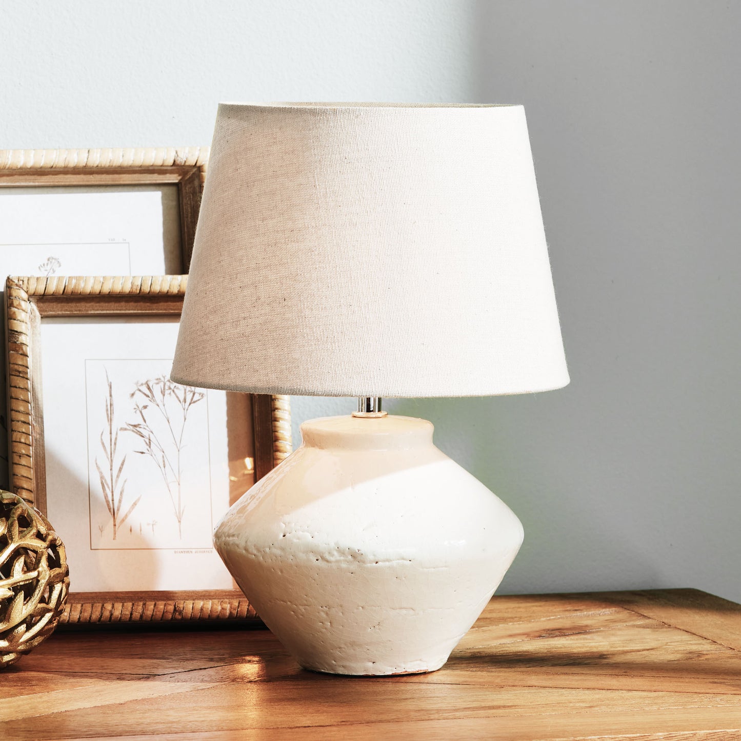 Glazed white mini lamp stylized on table.