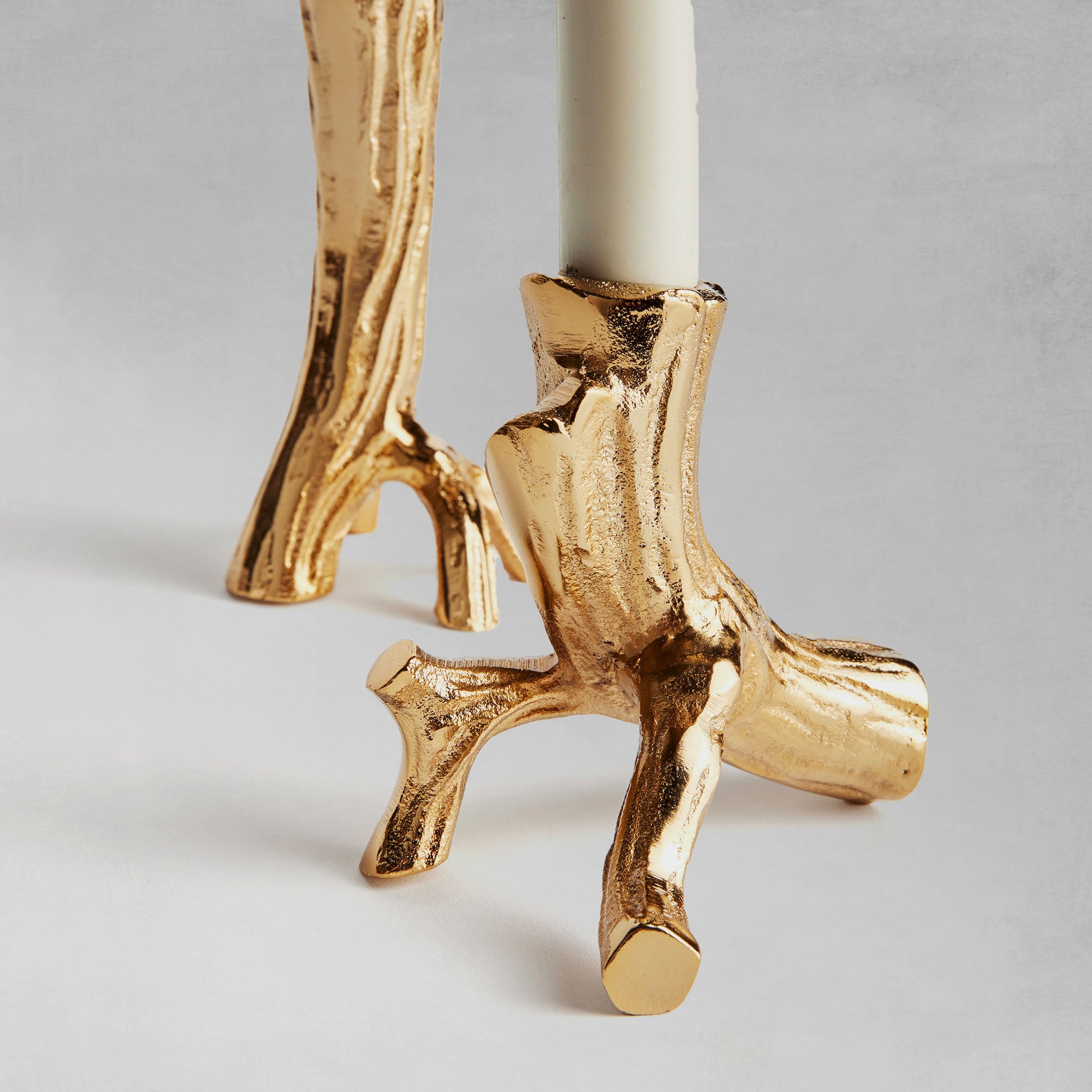 Gold driftwood taper candleholders, set of 2, closeup of candleholder base, with gray background.