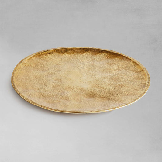 Gold round decorative tray with gray background.
