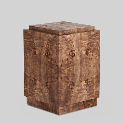 Dark burl wood plinth side table on gray background.