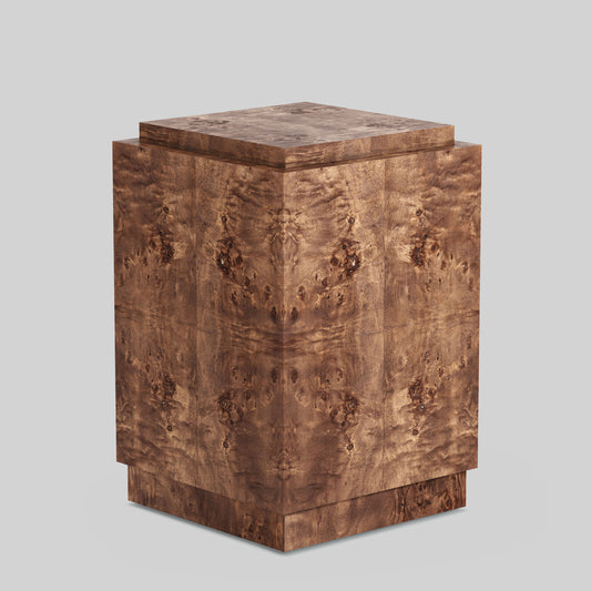 Dark burl wood plinth side table on gray background.