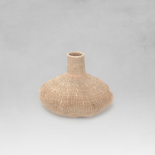Handwoven small binga basket with light gray background.