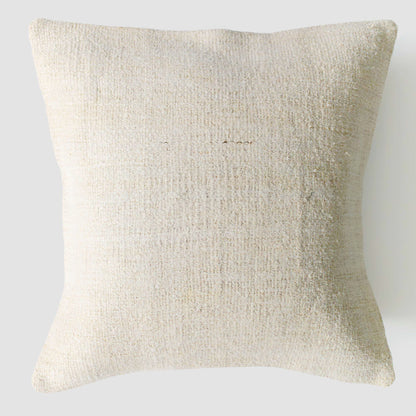 Beige textured pillow on a light gray background.