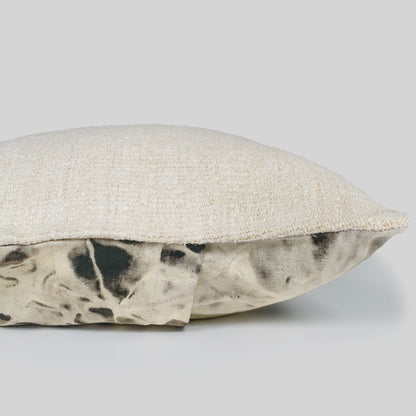 Textured pillow with a patterned trim on a gray background.