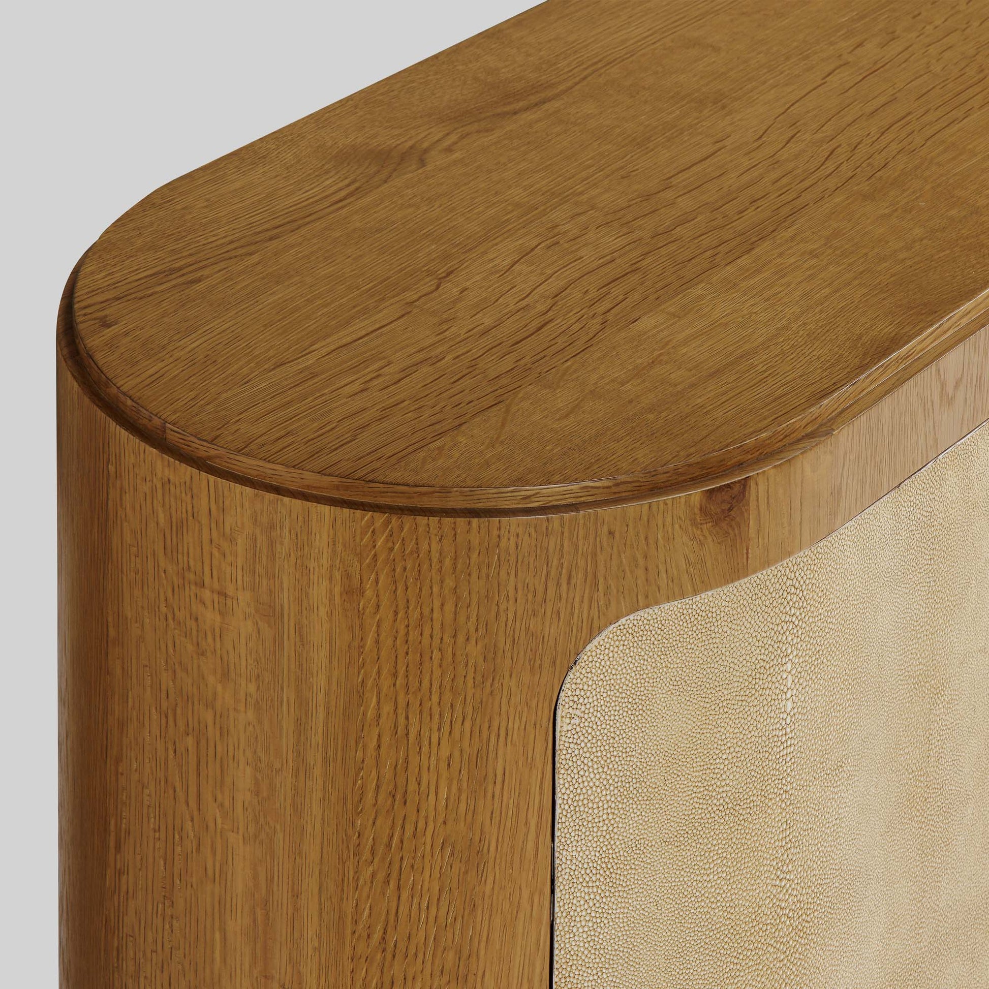 Natural oak sideboard with shagreen finished door panels on gray background.