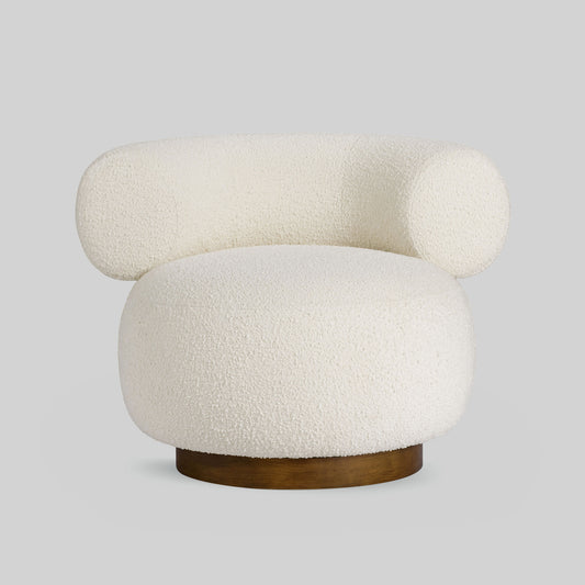 Light colored boucle fabric swivel chair on gray background.
