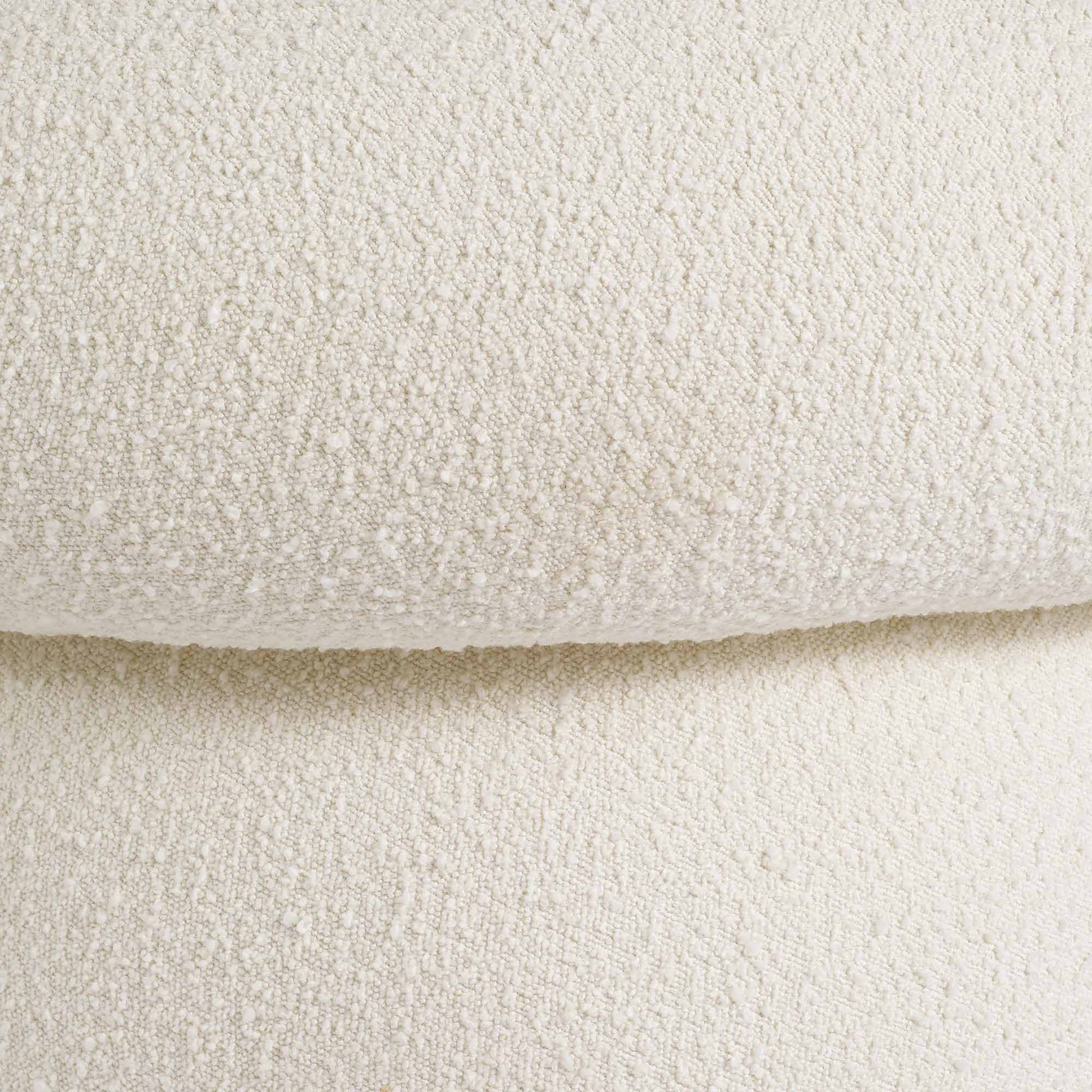 Light colored boucle fabric swivel chair on gray background.