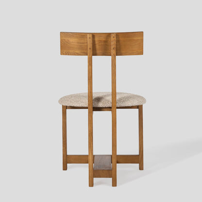 Wooden bar stool with a cushioned seat on a light gray background