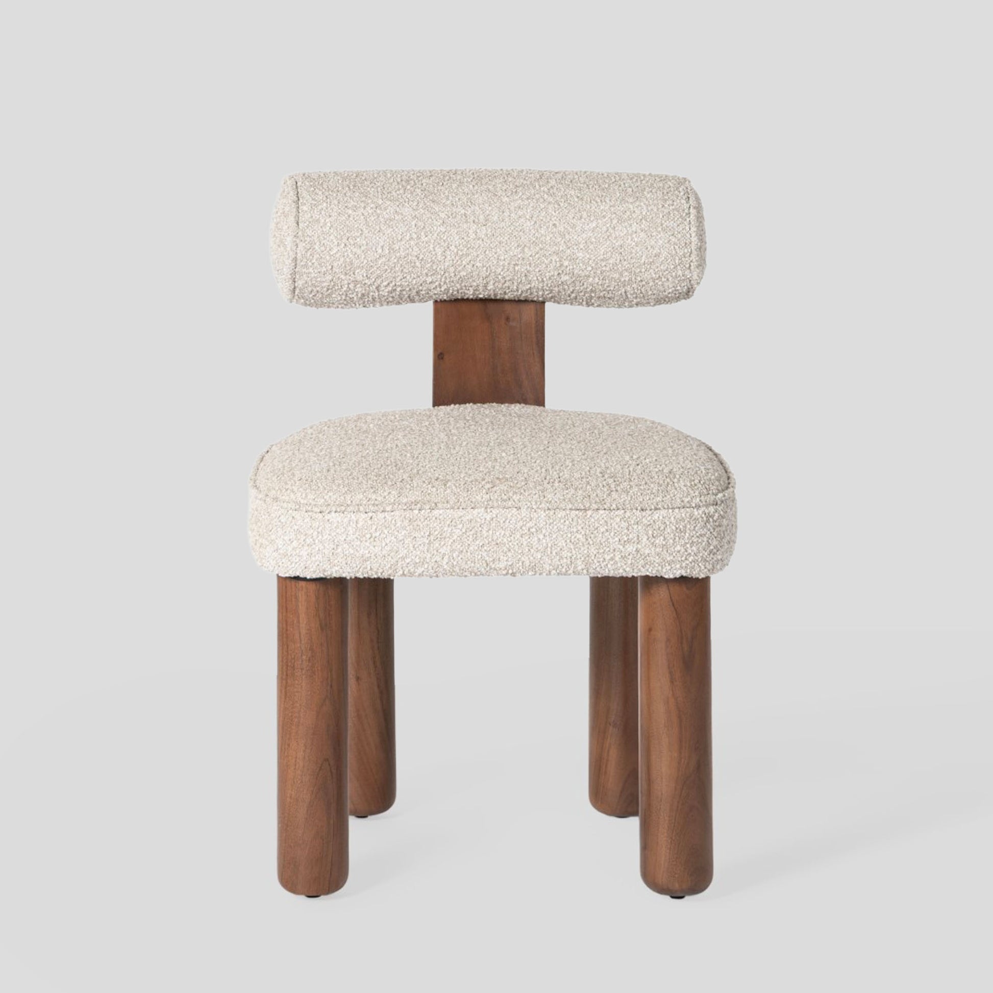 Chair with wooden legs and white cushioned seat and backrest on a light gray background