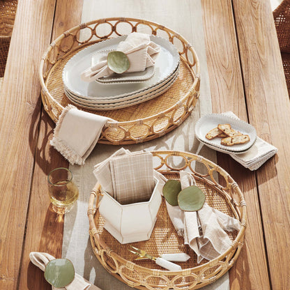 Lattice round rattan serving trays stylized on outdoor dining table.