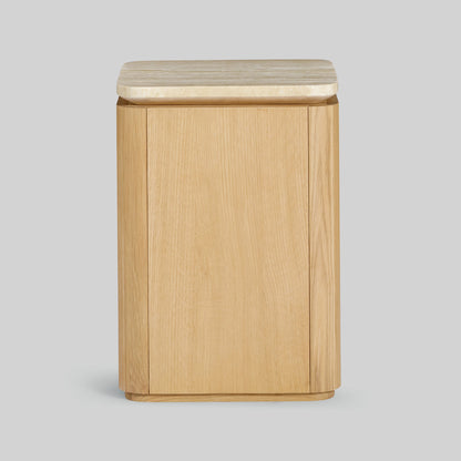 Wooden side table with a light oak finish and travertine top on a gray background.